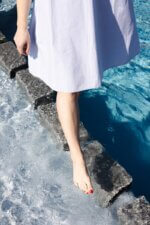 A person walks on stepping stones near water