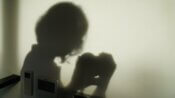 a shadow of a woman holding a cell phone