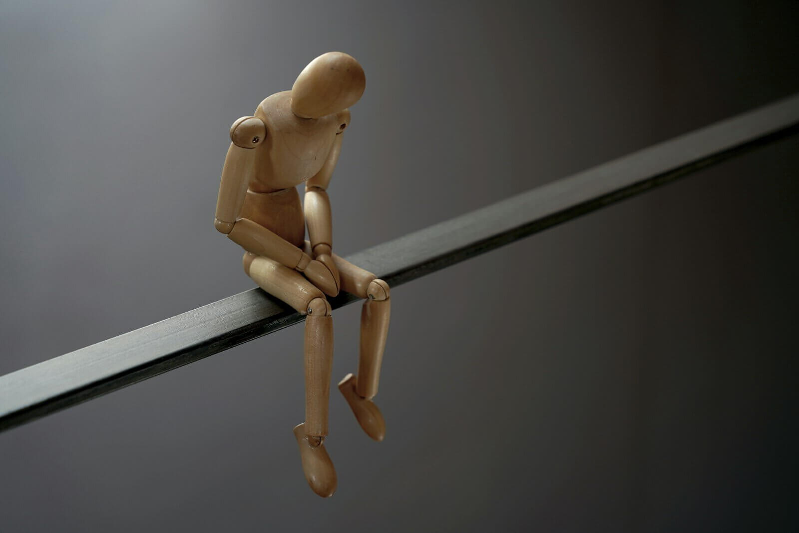a wooden toy sitting on top of a metal bar