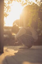 a person kneeling down on the ground with a backpack