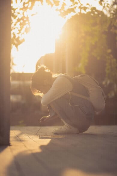a person kneeling down on the ground with a backpack