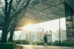 Man walking on path with city buildings in background