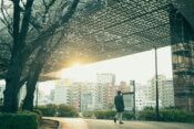 Man walking on path with city buildings in background